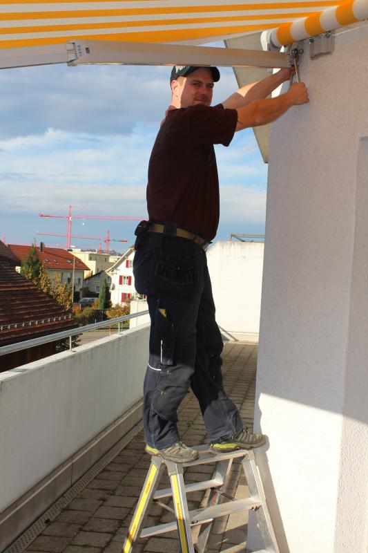 Monteur bei der Montage einer Markise